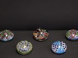 six bols en verre de couleurs différentes posés sur une surface noire