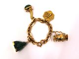 un gros plan d'un bracelet en or orné de breloques sur fond blanc