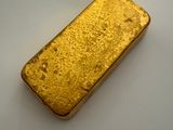 a gold bar sitting on top of a white surface