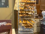 many donuts on a rack in a bakery