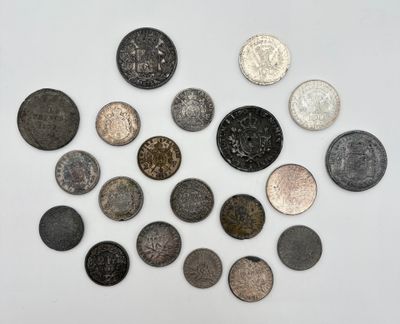 Plusieurs types de pièces de monnaie sont disposées en cercle sur une surface blanche