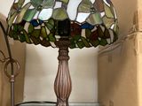 a lamp that is sitting on a shelf next to a lamp