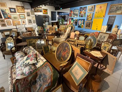 une pièce remplie de meubles anciens et de tableaux accrochés aux murs