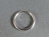 a silver ring that is on a gray surface