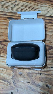 a white box with a black lid on a wooden table