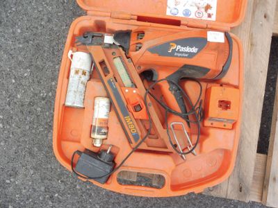 une mallette orange contenant une agrafeuse, une agrafeuse, un pistolet à clous et d'autres outils