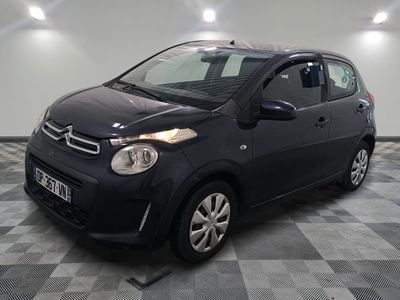 the small black car is parked on a checkered tile floor