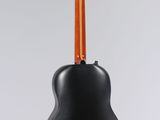 a black acoustic guitar hanging from a white wall