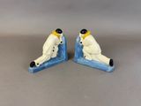 pair of ceramic figurines of a man and a woman sitting on a snowboard