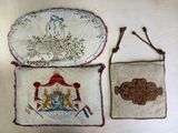 trois morceaux de tissu ornés de motifs brodés, posés sur une table