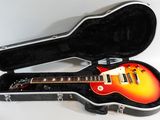 an electric guitar in a hard case on a white surface