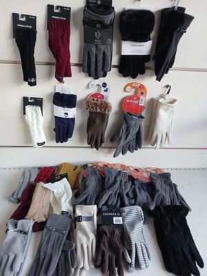 many pairs of gloves hanging on the wall next to each other