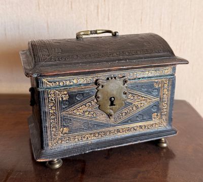 une petite boîte en métal posée sur une table en bois