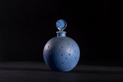 an image of a blue glass bottle on a black surface