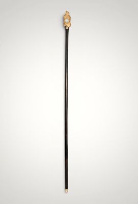 a black and gold cane with a wooden handle on a white background