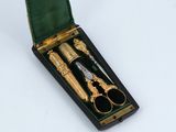 a pair of scissors in a box with a green case