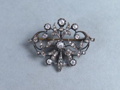 un gros plan d'une broche en argent sertie de diamants