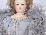 a doll that is sitting on a chair with a hat on