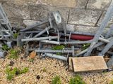 a pile of old tools sitting on the ground next to a brick wall