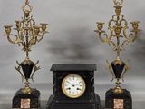 three black and gold clocks sitting next to each other