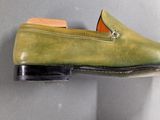 pair of men ' s green sued slippers hanging on a wall