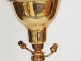 a gold colored lamp that is sitting on a table
