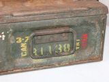 an old metal box with a metal handle on a table