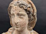 an old statue of a woman with a scarf on her head