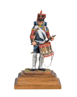 a toy soldier with a drum and drum stand on a wooden base