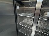 a refrigerator that is open in a room with a lot of shelves
