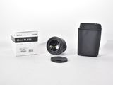the camera lens is next to a black case and a white box