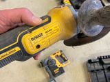 a person holding a hammer in their hand with other tools on the table
