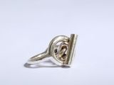 gros plan d'une bague en argent sur une surface blanche