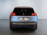 the rear end of a silver suv parked in a white room