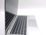 a silver laptop with a black keyboard on a white surface