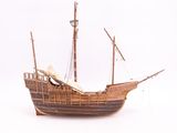 a wooden model of a boat on a white surface