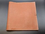 a brown leather passport case sitting on top of a black table