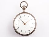 une montre de poche en argent avec des chiffres romains sur le cadran