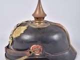 an old helmet with a golden crown on top of it on a white surface