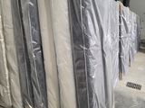 de nombreux matelas emballés dans du plastique dans un entrepôt