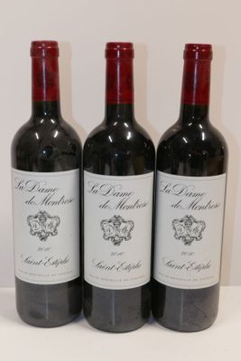 trois bouteilles de vin rouge sont alignées sur une surface blanche