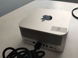 un ordinateur Apple blanc posé sur une table, avec un chargeur