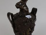 a bronze vase with a boy on top of it