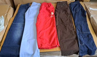 quatre paires de jeans dans une boîte posée par terre