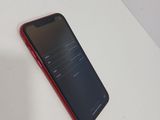 the back of a red phone sitting on top of a white table