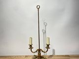 brass plated candelab with two candles on a wooden table