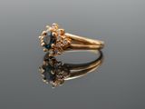 a close up of a gold ring with a blue diamond