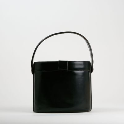 un sac seau noir muni d'une anse, sur fond blanc
