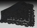 de la dentelle noire sur un tissu noir posé sur une surface blanche