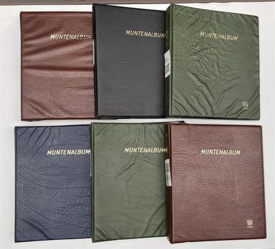 Quatre livres de couleurs différentes sont alignés sur une surface blanche